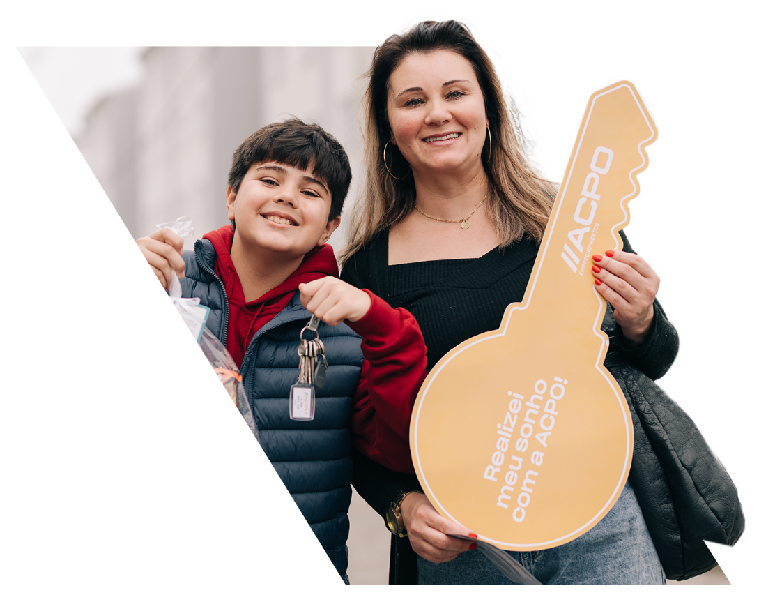 Mulher e criança segurando uma grande chave amarela com o texto 'Realizei meu sonho com a ACPO!'